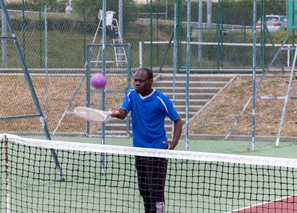 Défi sport : une jeune homme lance une balle au tennis