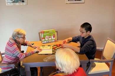 Partie de jeu entre un jeune garçon et une dame âgée