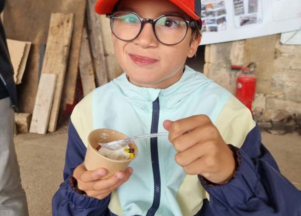 Une enfant se régale avec un pot de glace fermière