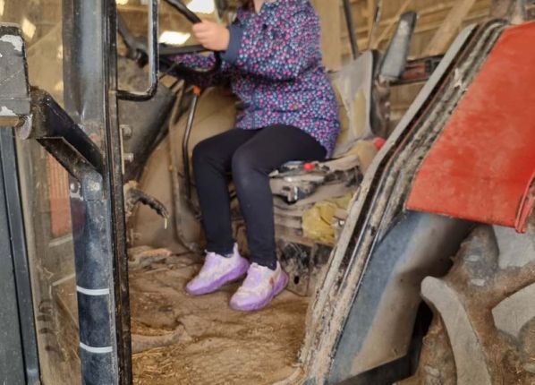 Une fille est installée au volant du tracteur
