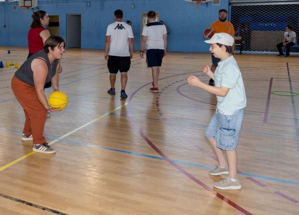 Défi sport : une adulte fait une passe de basket à un jeune garçon