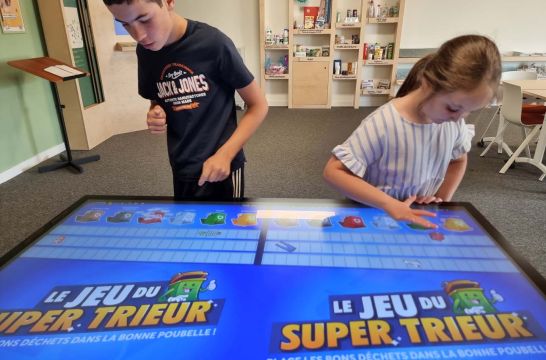 Un garçon et une fille essaient le jeu numérique du super trieur