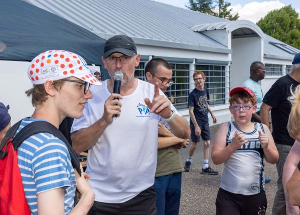 Défi sport : le coordinateur sportif annonce au micro entouré des participants