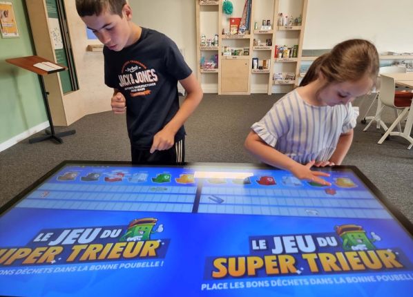 Un garçon et une fille essaient le jeu numérique du super trieur