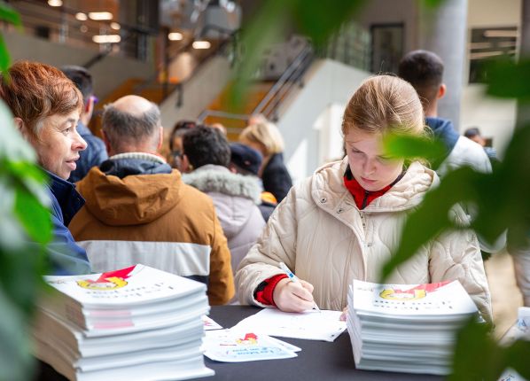 Photo de 2 personnes en activité pendant une séances de dédicaces au Festival de la BD avec les PEP18