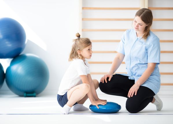 Une psychométricienne travaillant avec une jeune enfant dans un salle de motricité