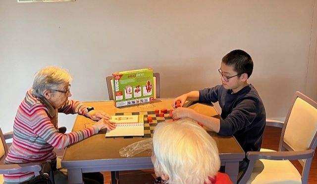 Partie de jeu entre un jeune garçon et une dame âgée