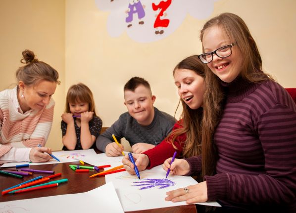 Educatrice en train de dessiner avec une groupe de jeunes enfant autiste