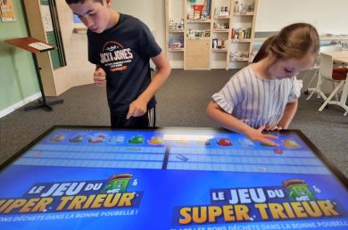 Un garçon et une fille essaient le jeu numérique du super trieur