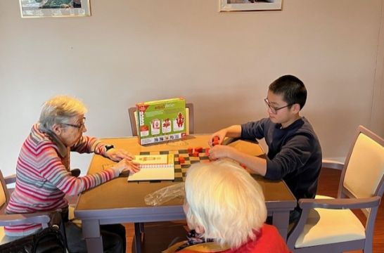 Partie de jeu entre un jeune garçon et une dame âgée