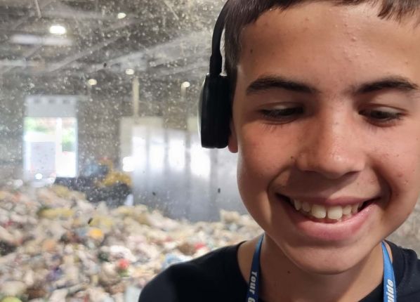 Un garçon porte un casque audio dans le centre de tri