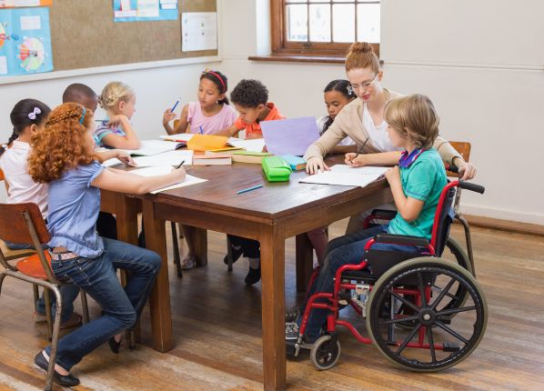 Educatrice en train de travailler l'écriture avec une groupe de jeunes enfants autistes