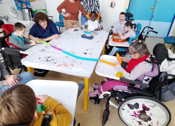 Educatrice lors d'un atelier sensoriel avec un groupe de jeunes enfants autistes dans un IZEP