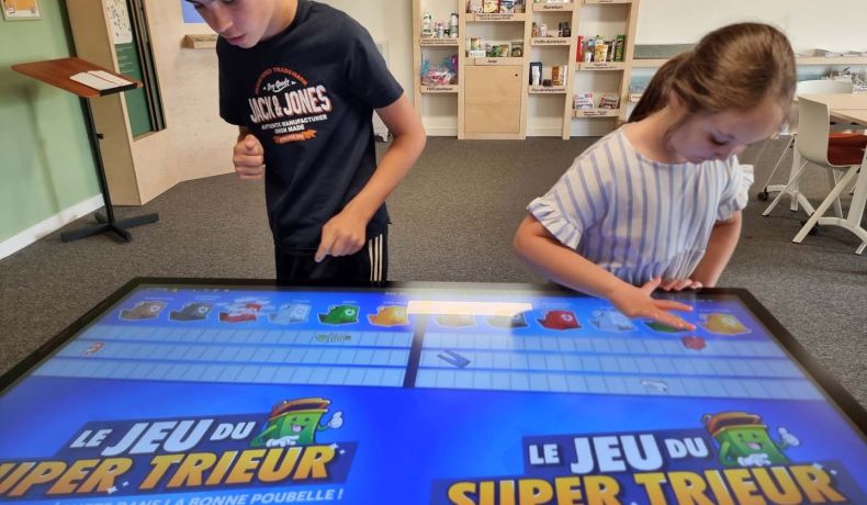 Un garçon et une fille essaient le jeu numérique du super trieur